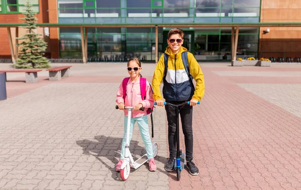 Schoolkinderen met rugzakken rijden steppen — Stockfoto