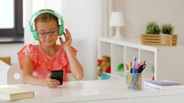 Chica en auriculares escuchando música en el teléfono celular — Vídeos de Stock