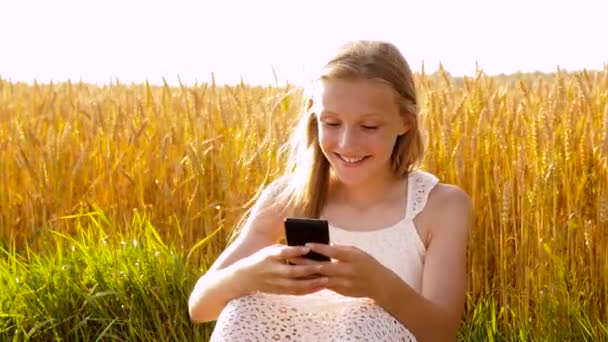 快乐的年轻女孩与智能手机在麦片领域 — 图库视频影像