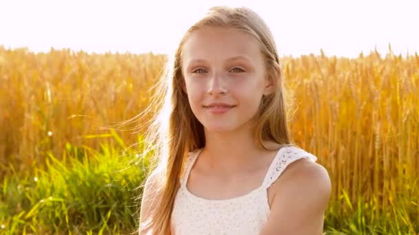 Smiling young girl on cereal field in summer — Stock Video