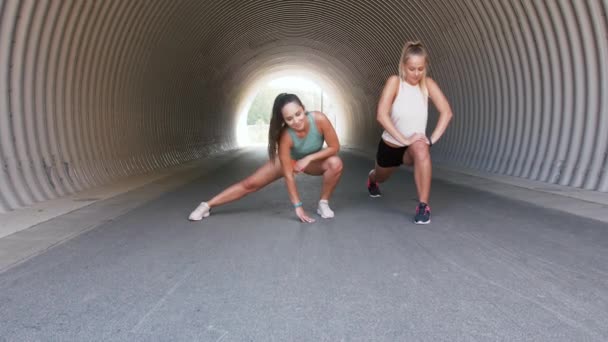 Vrouwen met fitness trackers die zich buiten uitstrekken — Stockvideo