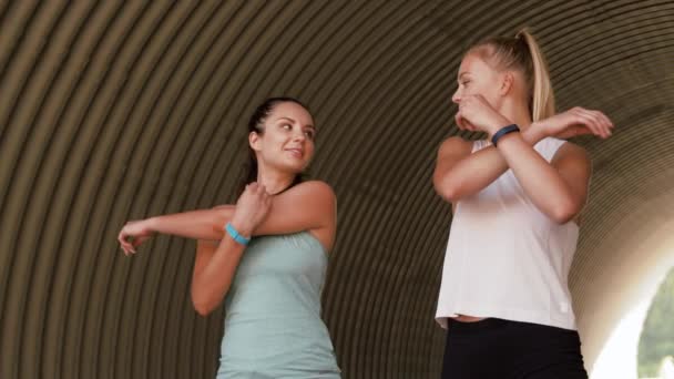 Frauen mit Fitness-Trackern dehnen sich im Freien — Stockvideo