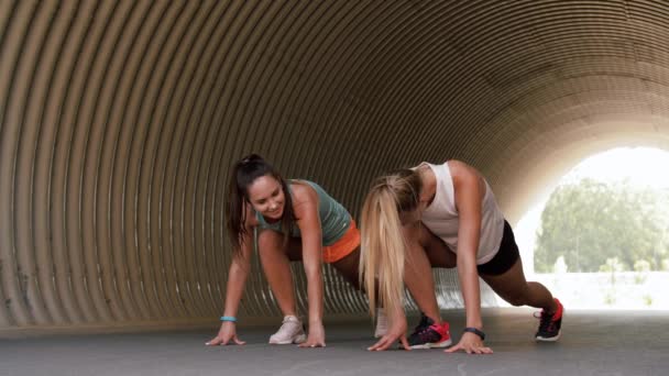 Kvinnor med Fitness trackers stretching utomhus — Stockvideo