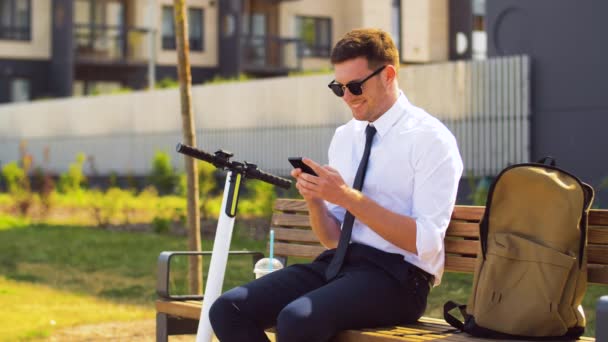 Hombre de negocios con teléfono inteligente bebiendo batido — Vídeos de Stock