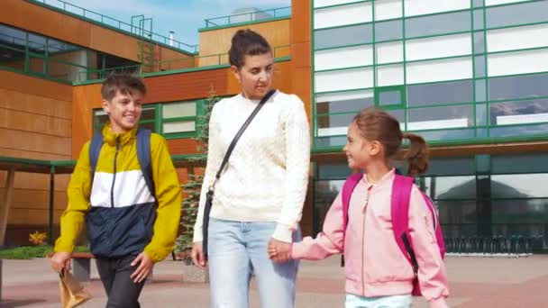 Madre prendendo il figlio e la figlia da scuola — Video Stock