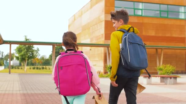 Дети с рюкзаками идут в школу — стоковое видео