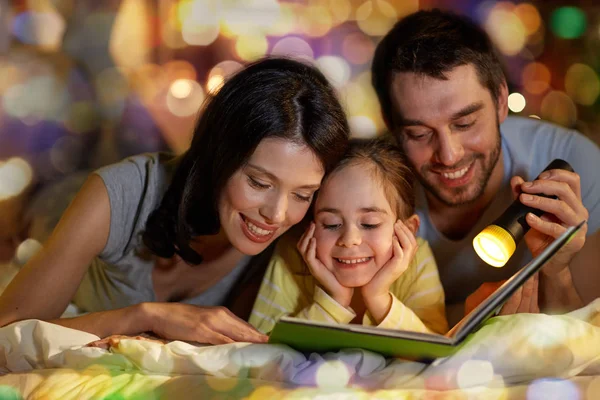 Libro de lectura familiar feliz en la cama por la noche en casa —  Fotos de Stock