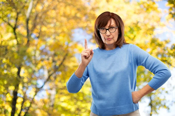 Displeased senior woman in glasses warning — Stock Photo, Image