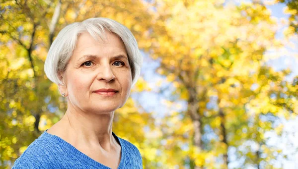 Portrét starší ženy v podzimním parku — Stock fotografie