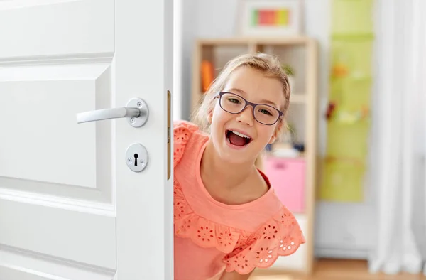 Felice sorridente bella ragazza dietro la porta di casa — Foto Stock