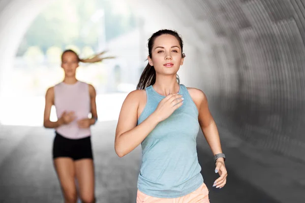 Mujeres jóvenes o amigas corriendo al aire libre —  Fotos de Stock