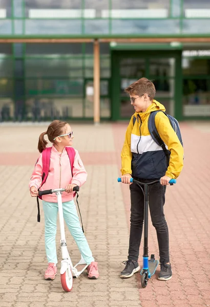 Szczęśliwe dzieci szkolne z plecakami i skuterami — Zdjęcie stockowe