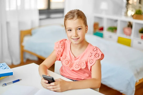 Menina estudante feliz usando smartphone em casa — Fotografia de Stock