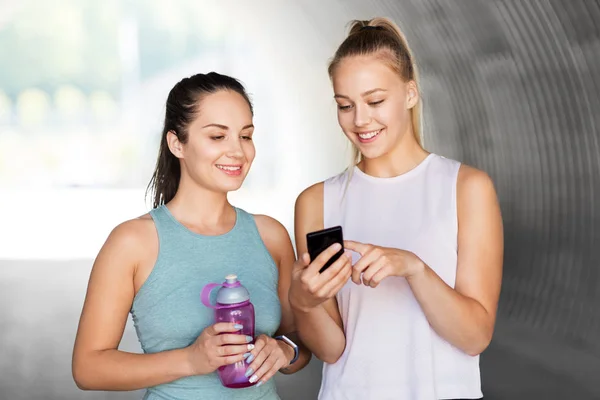 Frauen oder Freundinnen mit Smartphone und Fläschchen — Stockfoto