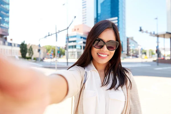 Mulher sorridente em óculos de sol tomando selfie na cidade — Fotografia de Stock