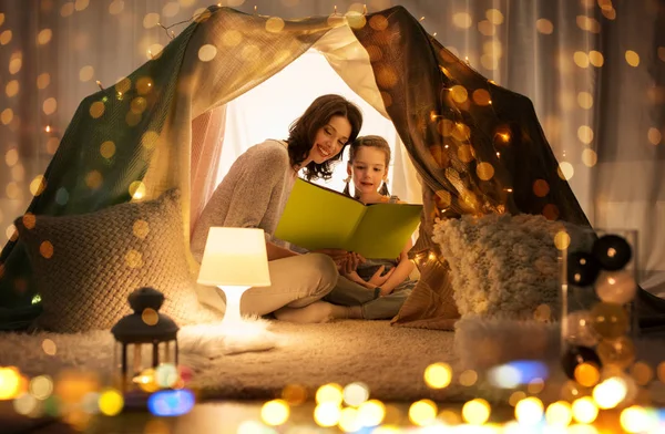 Felice famiglia lettura libro in tenda per bambini a casa — Foto Stock