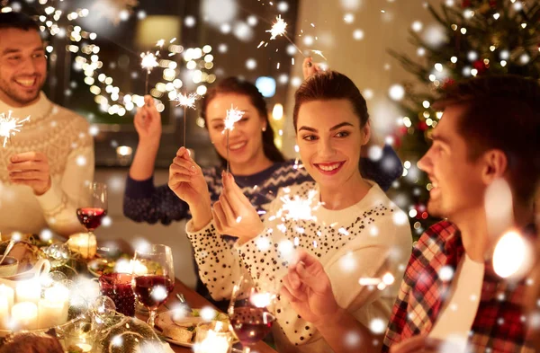 Šťastní přátelé slaví Vánoce na domácí hostině — Stock fotografie