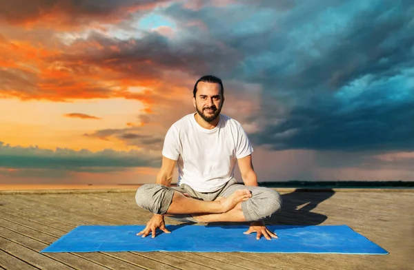 Человек делает yoga в маштабе представления на открытом воздухе — стоковое фото