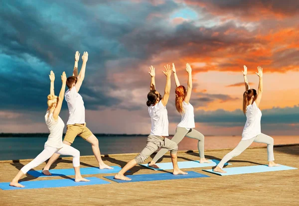 Grupo de personas haciendo ejercicios de yoga al aire libre —  Fotos de Stock