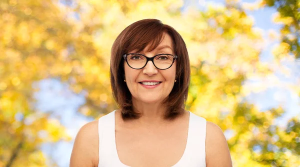Portrét starší ženy z brýlí na podzim — Stock fotografie