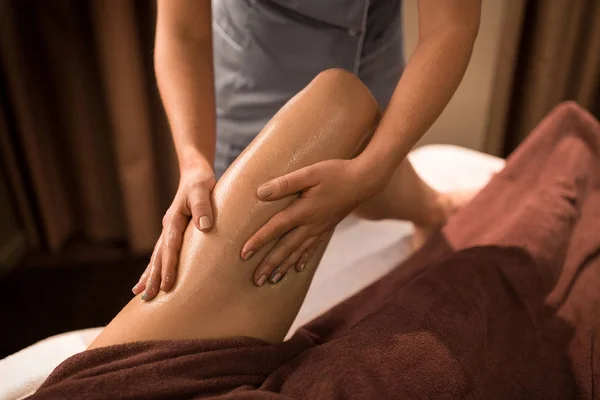 Mulher deitada e tendo massagem nas pernas com gel no spa — Fotografia de Stock