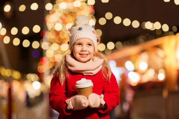 Šťastná dívka s šálkem čaje na vánočním trhu — Stock fotografie