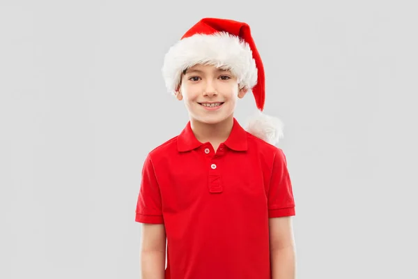 Ragazzo sorridente in t-shirt rossa e cappello da Babbo Natale — Foto Stock