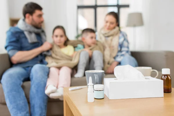 Medicamentos na mesa e família doente em casa — Fotografia de Stock