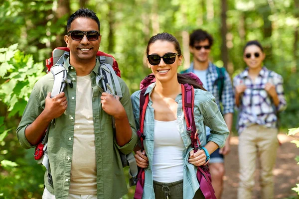 Group of friends with backpacks hiking in forest — Stock Photo, Image