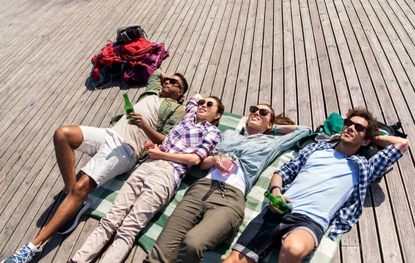 Friends drinking beer and cider on wooden terrace — Stock Photo, Image