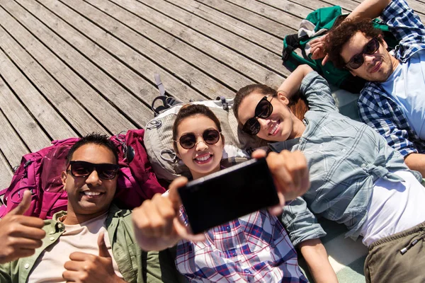 Vrienden of toeristen met rugzakken selfie — Stockfoto