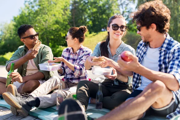 Gelukkige vrienden picknicken in het zomerpark — Stockfoto