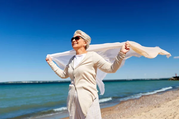 Donna anziana con sciarpa ondulante sulla spiaggia in estonia — Foto Stock