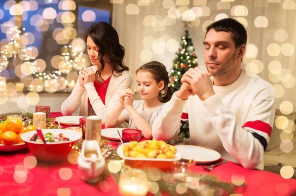 Family praying before meal at christmas dinner — Stock Photo, Image