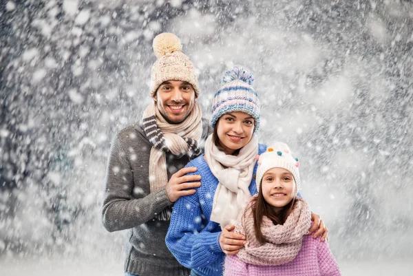 Щаслива сім'я в зимовому одязі на сніговому фоні — стокове фото