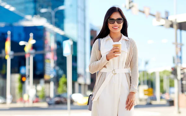 Mujer sonriente con taza de café para llevar en la ciudad —  Fotos de Stock