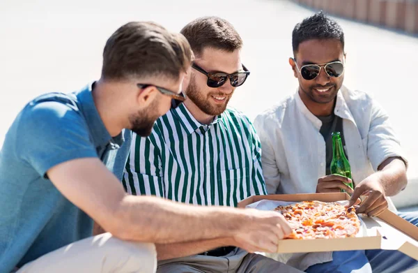 Чоловіки друзі їдять піцу з пивом на вулиці — стокове фото
