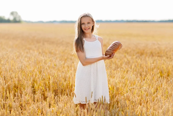 Ragazza con pagnotta di pane bianco sul campo di cereali — Foto Stock