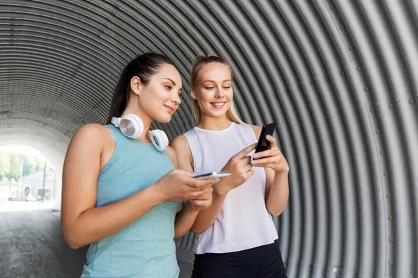 Women or female friends with smartphones — Stock Photo, Image