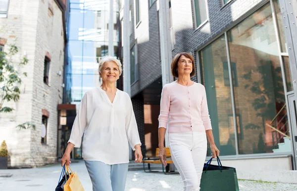 Senior vrouwen met boodschappentassen wandelen in de stad — Stockfoto