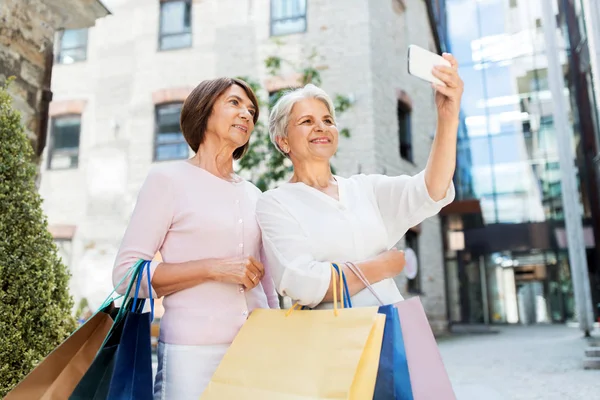 Gamla kvinnor med shoppingväskor tar Selfie i City — Stockfoto