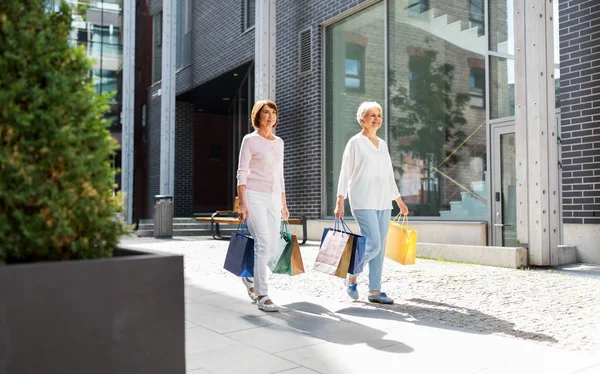 Mulheres idosas com sacos de compras andando na cidade — Fotografia de Stock