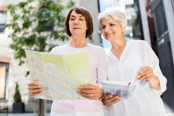 Donne anziane con guida della città e mappa sulla strada — Foto Stock
