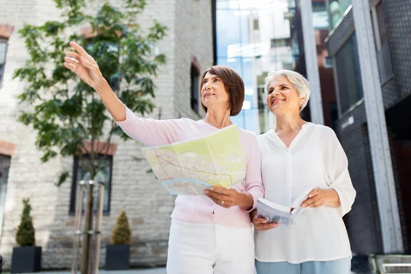 Senior women with city guide and map on street — Stock Photo, Image