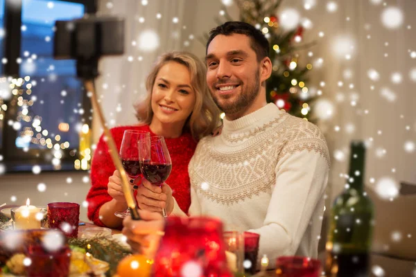 Couple taking picture by selfie stick at christmas — Stock Photo, Image