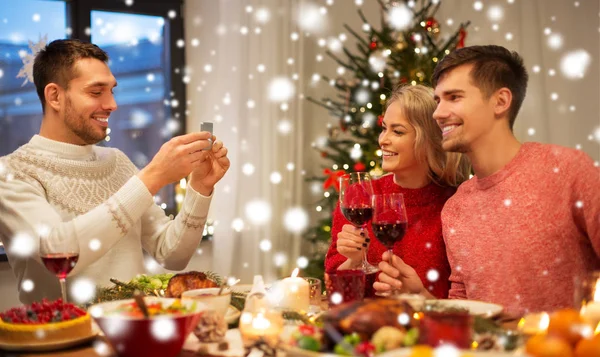 Glada vänner fotografering på julbord — Stockfoto