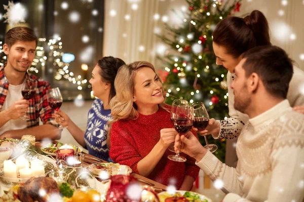 Amigos celebrando la Navidad y bebiendo vino —  Fotos de Stock