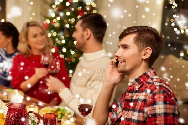 圣诞大餐的时候用智能手机打电话的男人 — 图库照片