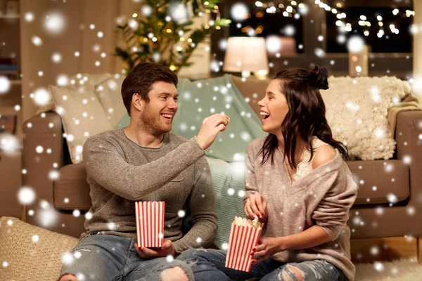 Feliz pareja comiendo palomitas de maíz en casa — Foto de Stock