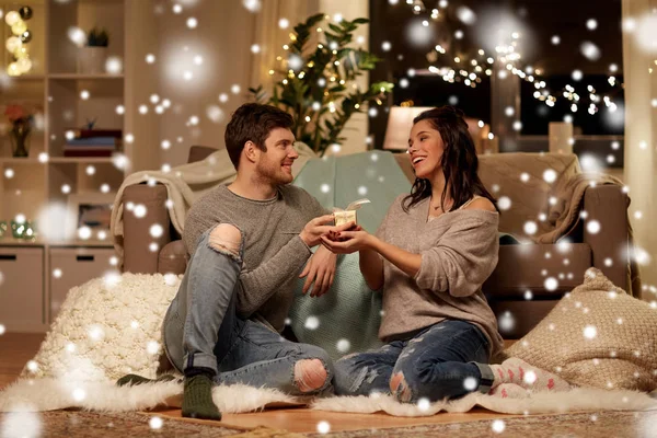 Couple heureux avec boîte cadeau à la maison — Photo